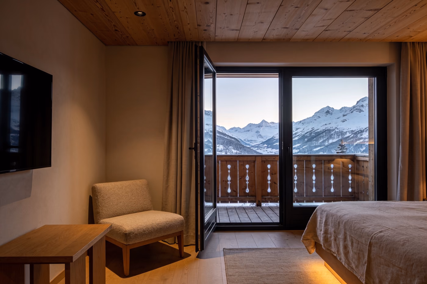Junior Suite mit Sofa und offener Balkontür zu den Bergen
