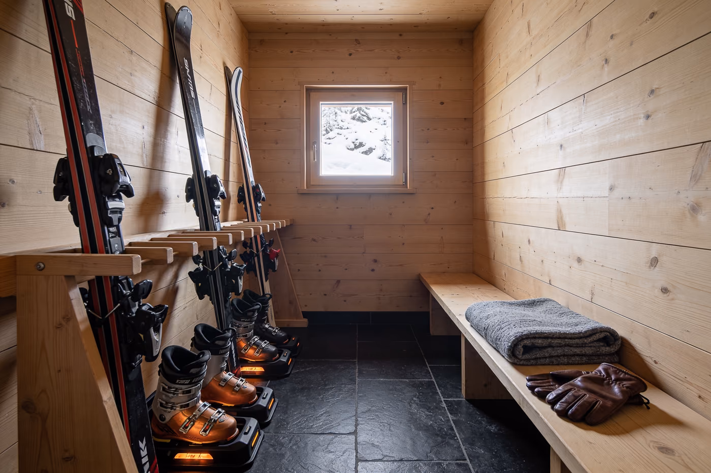 Beheizter Skiraum mit Skiern in Holzständern und Schuhtrocknern